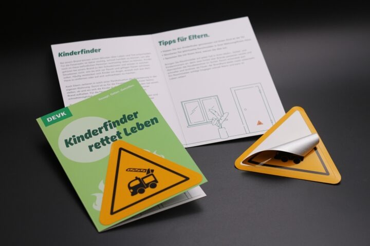 DEVK Kinderfinder-Aufkleber mit einer bedruckten Klappkarte mit Tipps für Eltern zum Einsatz des Aufklebers