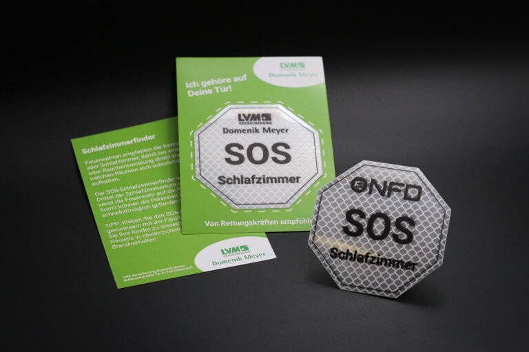 Ein reflektierender Aufkleber mit einer zusätzlichen Papierkarte. Der SOS Aufkleber wird an die Schlafzimmertür geklebt.